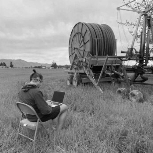 Black & White photo of our CTO working in the field, next to a reel