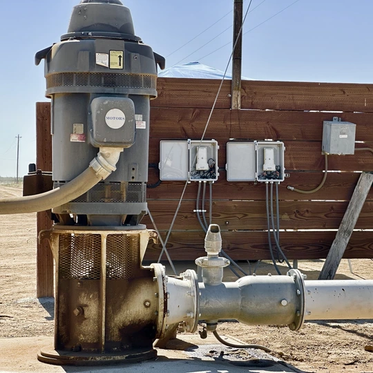 two-devices-side-by-side-with-a-pump-in-foreground Irrigation Timers on FarmHQ equipped pumps